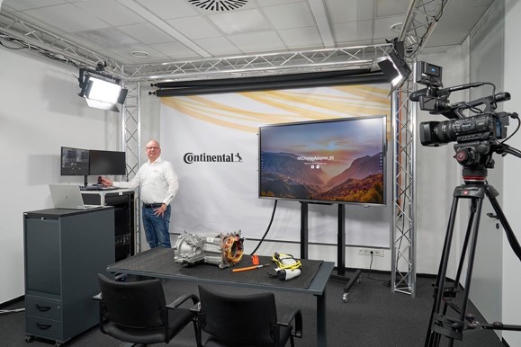 TV-Studio der ContiAcademy mit Fernseher, einer großen Kamera, technischen Ausstellungsstücken und einer Person in weißem Hemd.